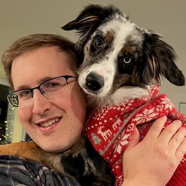 Picture of Ben Bahrman and his dog, a gray merle Australian Shepherd.